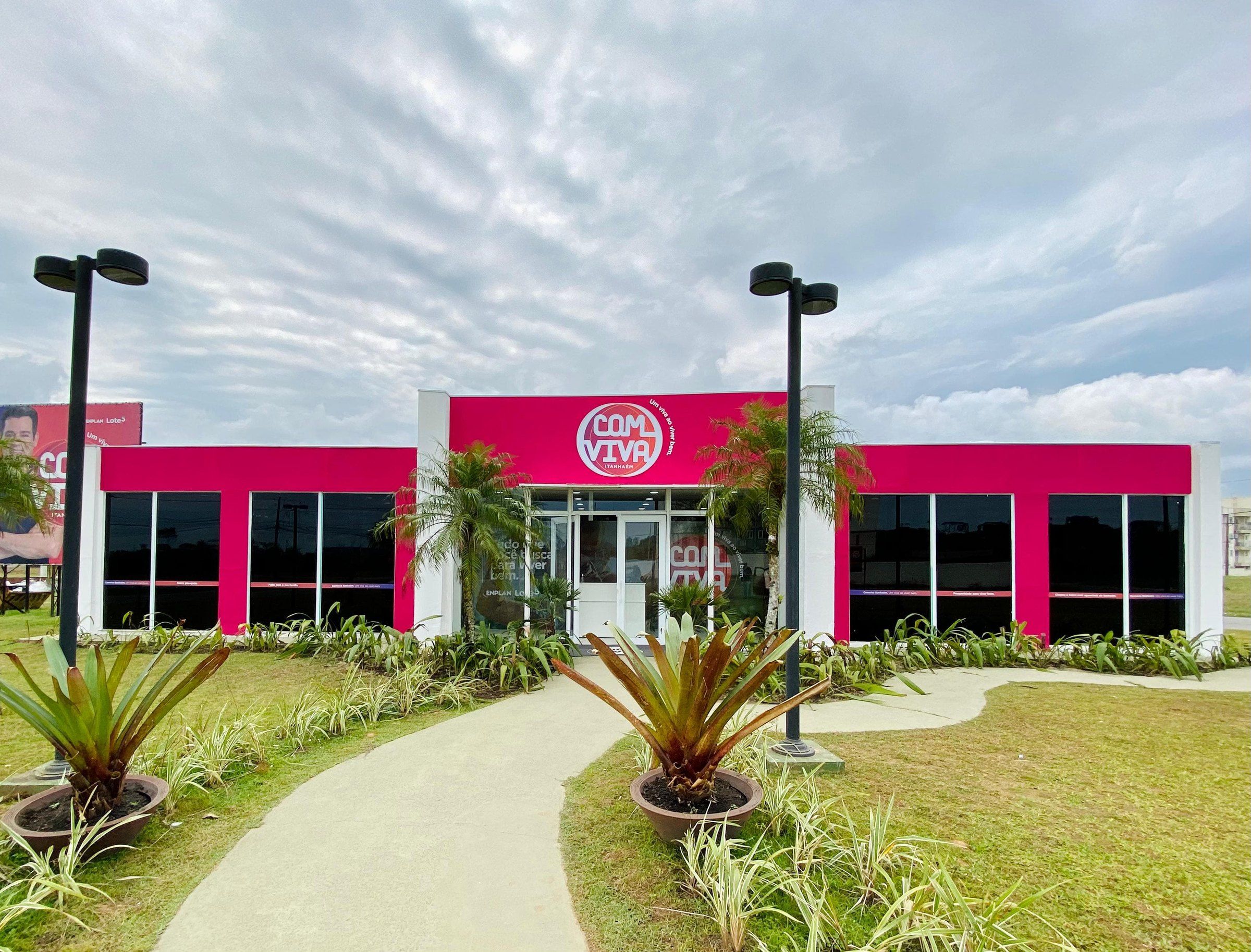 Estande de vendas Com Viva com fachada magenta e jardim na frente